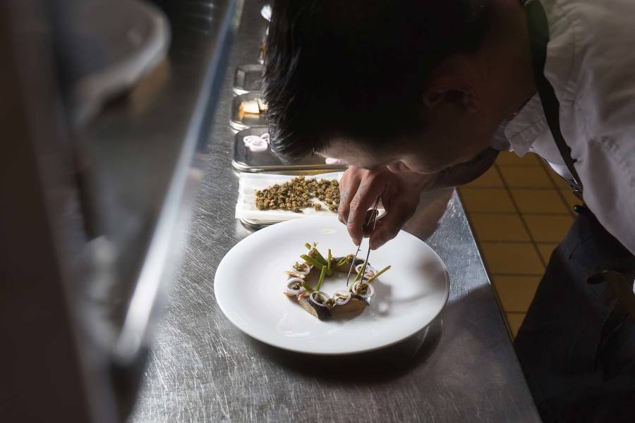 A chef demonstrates his food-styling skills as he patiently prepares Greenlandic herring