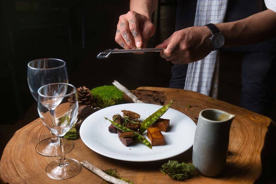 A chef puts finishing touches to a caribou dish served with Labrador tea