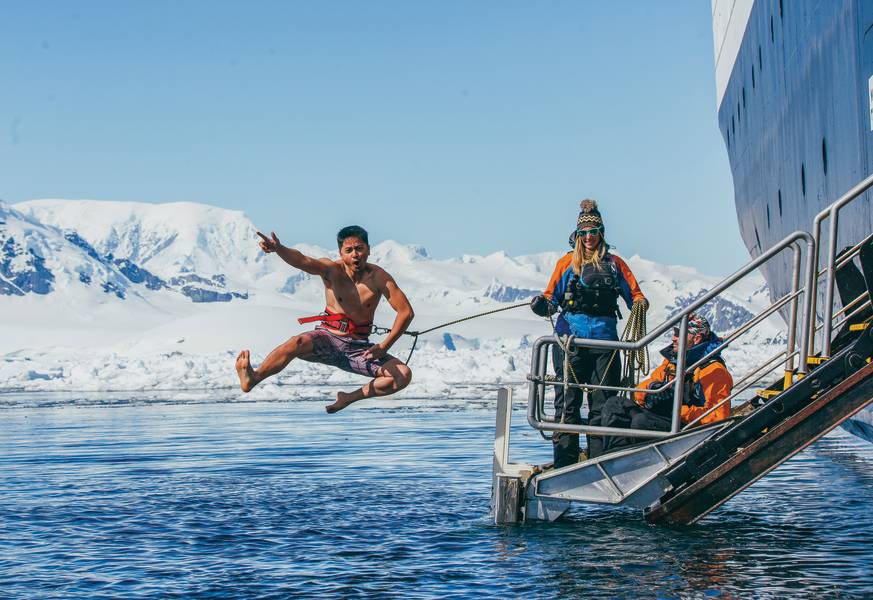 A guest jumps off the gangway (with a safety harness) into Antarctic waters during the Polar Plunge.