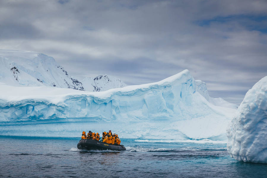 Guests zodiac cruise near an iceberg on one of our excursions.