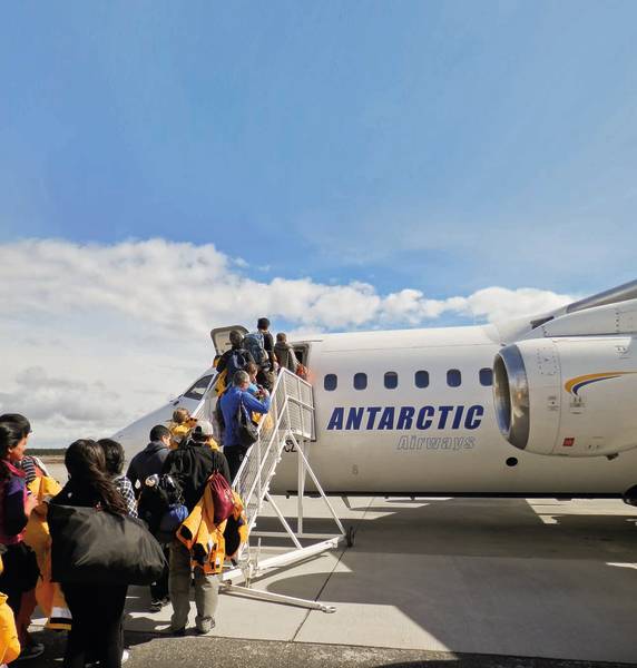 Guests going up stairs as their board our chartered flight from Punta Arenas, Chile.