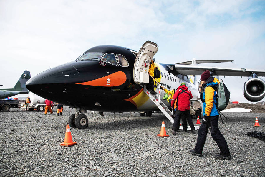 A guest sets foot in Antarctica after disembarking a their penguin-paint job plane on one of our Fly/Cruise voyages.