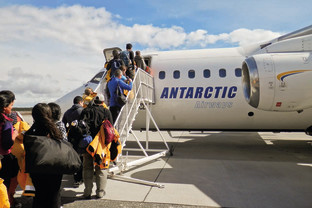 Guests going up stairs as their board our chartered flight from Punta Arenas, Chile.