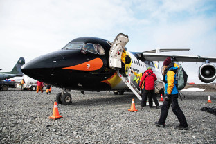 A guest sets foot in Antarctica after disembarking a their penguin-paint job plane on one of our Fly/Cruise voyages.