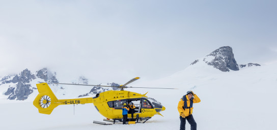 Passengers disembark from a Quark Expeditions Helicopter onto snow covered land