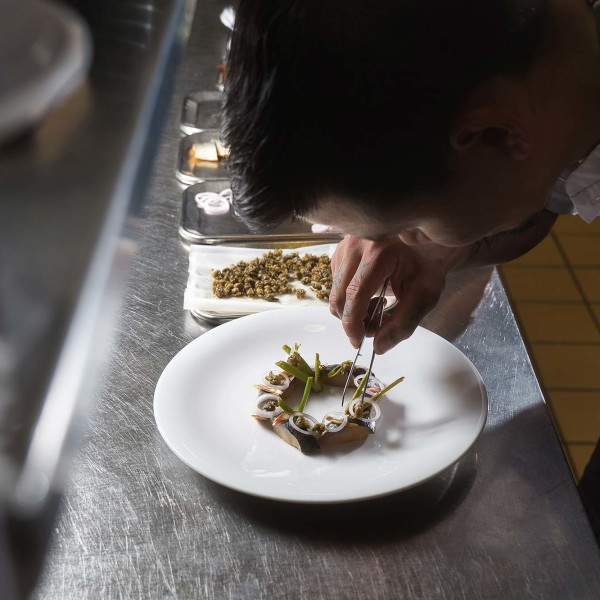 A chef demonstrates his food-styling skills as he patiently prepares Greenlandic herring