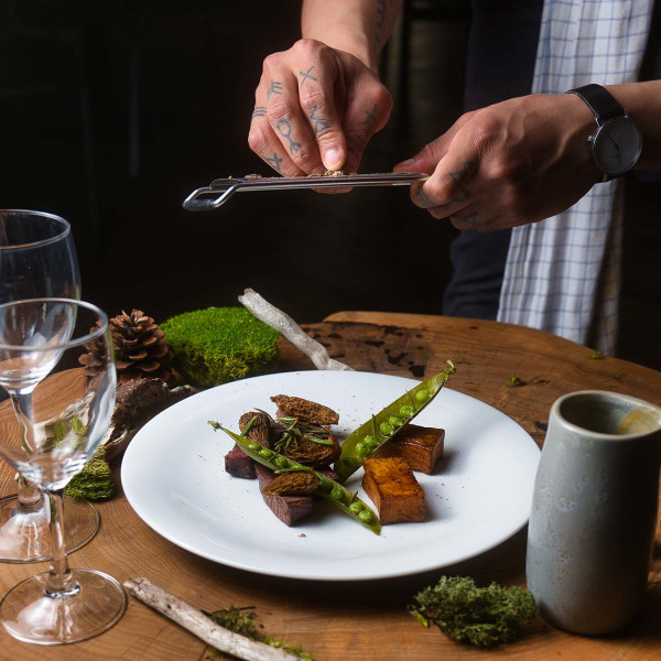 A chef puts finishing touches to a caribou dish served with Labrador tea