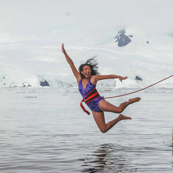 May Lee soars off the gangplank into an icy Antarctic bay during the Polar Plunge, a popular rite of passage on polar expeditions