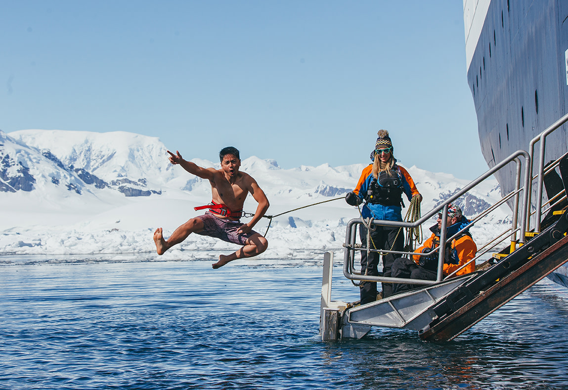 A guest jumps off the gangway (with a safety harness) into Antarctic waters during the Polar Plunge.